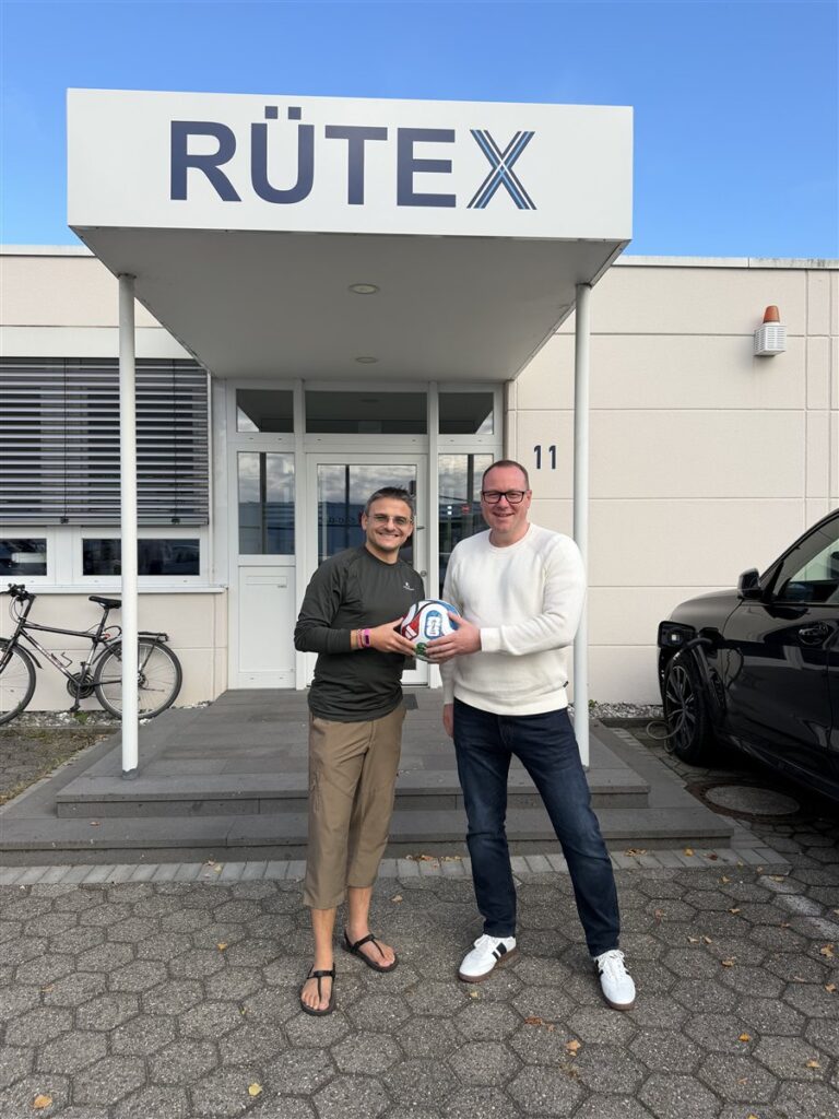 WM-Tippspiel: Björn Fox (Avantgarde) übergibt den Fußball an Herrn Doffek vor dem Rütex-Gebäude